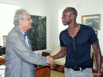 Alex Bunbury (right) meeting Minister of Education Dr Rupert Roopnaraine during his recent visit (Ministry of Education photo)