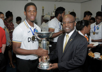 Shimron Hetmyer  and Minister Stephen Lashley show off the World Cup trophy during the West Indies Under-19s arrival at the Grantley Adams International Airport in Barbados on Tuesday. WICB Media Photo/Randy Brooks 