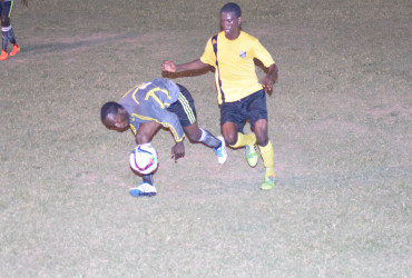 Orin Yarde (right) of Santos FC in the process of challenging a Flamingo player for possession of the ball during their team’s matchup in the GFA Stag Beer First Division League at the GFC ground, Tuesday night.