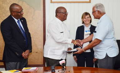 Minister of Finance Winston Jordan (second from left) handing over the agreement to Minister of Agriculture, Noel Holder in the presence of Minister of State, Joseph Harmon (left) and World Bank official Sophie Sirtaine. (GINA photo)  