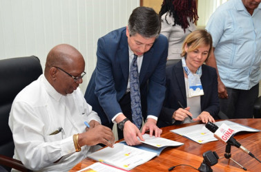 Minister of Finance, Winston Jordan (left) and Sophie Sirtaine, World Bank Country Director, Caribbean Country Management Unit Latin America and the Caribbean Region signing the US$3M agreement for the rehabilitation of the Cunha Canal (GINA photo) 