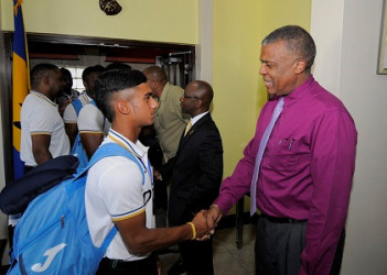 Trinidadian Kirstan Kallicharan is greeted by West Indies Cricket Board chief executive, Michael Muirhead, on the team’s return to the region on Tuesday. (Photo courtesy WICB Media) 