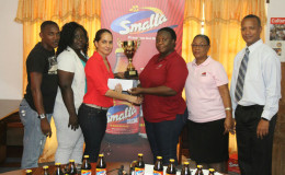 Ansa McAL, Anjeta Hinds handing over the sponsorship cheque to Assistant Secretary/Treasurer of the AAG, Amanda Hermanstine yesterday at Olympic House. Hinds and Hermanstine are flanked by AAG’s president, Aubrey Hutson and other members of the AAG.