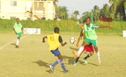 Curtez Kellman of Chase Academy (green) in the process of challenging an East Ruimveldt player for possession of the ball during their team’s matchup in the 4th Annual Milo Secondary School u-20 Championship yesterday at the Ministry of Education Ground, Carifesta Avenue.