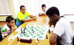 During the Trophy Stall chess tournament, the youths demonstrated an appreciation for each other’s games by sometimes physically supporting their colleagues. In this photograph, University of Guyana geological engineering second year student Owen Mickle (right) playing the white chess pieces, takes on Ghansham Allijohn of St Stanislaus College. The two onlookers are Kristoff Prashad with glasses and John Wong. The entire entourage has its roots in the robust St. Stanislaus College’s Chess Club.
