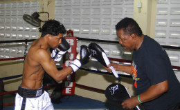 Elton ‘The Bully’ Dharry is here and focused on continuing his ascension in the world bantamweight ranks. Dharry is seen here yesterday putting work in at the Andrew ‘Sixhead’ Lewis Gym under the watchful eyes of trainer, Lennox Blackmore. (Orlando Charles photo)
