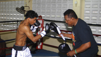 Elton ‘The Bully’ Dharry is here and focused on continuing his ascension in the world bantamweight ranks. Dharry is seen here yesterday putting work in at the Andrew ‘Sixhead’ Lewis Gym under the watchful eyes of trainer, Lennox Blackmore. (Orlando Charles photo) 