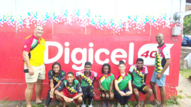 Members of the Guyana Junior Squash team pose for a photo opportunity along with team manager David Fernandes (left) and coach Garfield Wiltshire (right) at the St. Vincent & The Grenadines Junior Squash Open 2016 championships last weekend. 