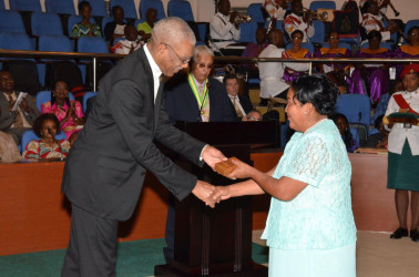 Bernadette Allicock from the Makushi Research Unit receiving the Medal of Service award from President David Granger. (Ministry of the Presidency photo)