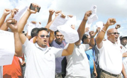 Former employees of Centrin display their dismissal letters outside the company’s compound, Point Lisas, Couva, on Thursday, where they called on Prime Minister Dr Keith Rowley to intervene on their behalf. 