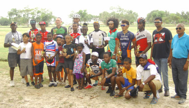 The prize winners along with veteran cycle coach and race organizer Hassan Mohammed, right, following the conclusion of yesterday’s event. (Orlando Charles photo).   