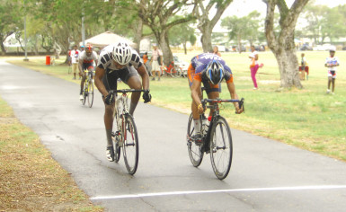 Team Alanis’ Paul DeNobrega (right) edges TGE’s Marlon Williams to take the spoils of the BR Investment/Dookie Construction criterium programme yesterday at the National Park. (Orlando Charles photo)