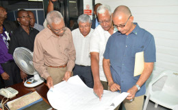 President David Granger looks at a plan of the GuySuCo facility with (from right) Director of Protocol at the Ministry of the Presidency Col Francis A Abraham, Minister of Agriculture Noel Holder and Chief Executive Officer of GuySuCo Errol Hanoman. (Ministry of the Presidency photo)
