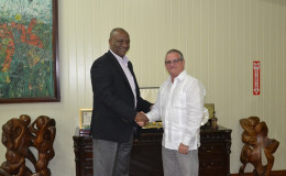 Cuban envoy, Julio Cesar Gonsalez Marchante (right) meeting with Minister of State, Joseph Harmon, today. (Ministry of the Presidency photo)