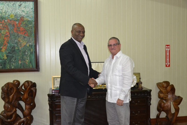 Cuban envoy, Julio Cesar Gonsalez Marchante (right) meeting with Minister of State, Joseph Harmon, today. (Ministry of the Presidency photo)