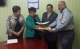Ministers Amna Ally and Sydney Allicock and Dr. Suresh Narine (at right) exchanging copies of the MoU, while Minister within the Ministry of Indigenous People’s Affairs Valerie Garrido-Lowe looks on. (Ministry of the Presidency photo)
