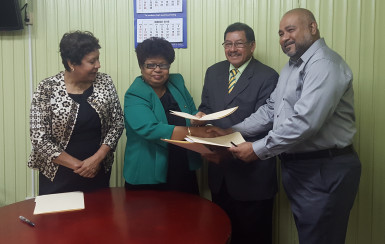 Ministers Amna Ally and Sydney Allicock and Dr. Suresh Narine (at right) exchanging copies of the MoU, while Minister within the Ministry of Indigenous People’s Affairs Valerie Garrido-Lowe looks on. (Ministry of the Presidency photo) 