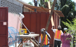 City Hall workers removing wood which formed part of an overhanging shed attached to Andrew’s Supermarket. (Photo by Keno George)