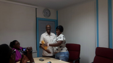 Sharon Mars yesterday collecting from GGMC Compliance Officer Derek Lawrence at the GGMC office on Brickdam.