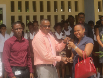 Project Director Michael Singh hands over the keys to the new building to Pauline Lucas, Regional Executive Officer of Region Four, as students look on.  