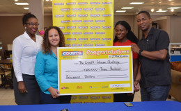 Court’s Marketing Manager, Pernell Cummings (right) hands over the cheque to CrossFit Event Organiser Jordana Ramsay-Gonsalves as brain child of the fixture Noshavyah King (2nd right) and Marketing Officer Roberta Ferguson look on.(Orlando Charles photo)