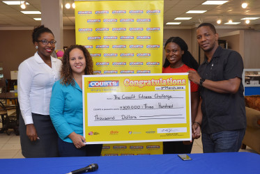 Court’s Marketing Manager, Pernell Cummings (right) hands over the cheque to CrossFit Event Organiser Jordana Ramsay-Gonsalves as brain child of the fixture Noshavyah King (2nd right) and Marketing Officer Roberta Ferguson look on.(Orlando Charles photo)