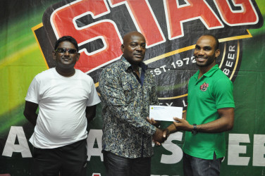 EBFA President Franklin Wilson (centre) receiving the sponsorship cheque from Stag Beer Brand Representative Lindon Henry following the launch of the EBFA Stag Beer 1st division league yesterday at the Ansa McAl boardroom. 