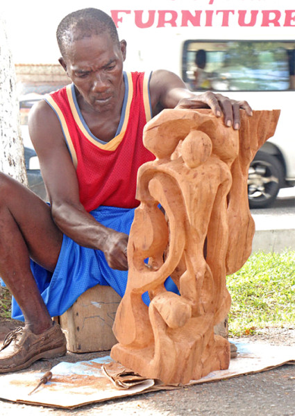 Sculptor Marvin Phillips working on a piece of art on Main Street back in September 2014. (Stabroek News file photo) 