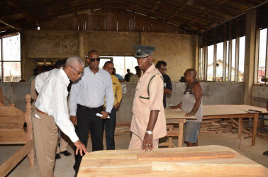 President David Granger (left)  examining some of the work done by inmates at the Mazaruni Penal Settlement. (Ministry of the Presidency photo) 