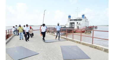 Minister within the Ministry of Public Infrastructure, Annette Ferguson (centre) along with a group of engineers inspecting the Supenaam stelling. (GINA photo)