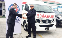 Associate Professor of International Relations and Director of South America of TIKA, Mehmet Ozkan (left) hands over the keys to the ambulances to Public Health Minister, Dr. George Norton (Ministry of Public Health photo)
