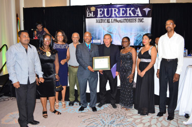Minister of Public Health, Dr. George Norton and CEO of Eureka Medical Lab (centre) W. Andrew Boyle flanked by others as they display the ISO accreditation certificate. 