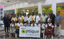 General Manager and co-founder of Optique Vision Care Dhani Andrew Narine (standing back row second from right) with the beneficiaries, staff and others.