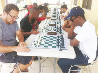 At last month’s Trophy Stall chess tournament, the first of 2016, players and onlookers experienced a choice morsel of overseas competition - a tidbit of strong international chess. Before the tournament actually began curiosities were aroused. Players wanted to know how strong our visitor was. We learnt he was from Mexico. Pockets of discussion were taking place quietly and purposefully. Players were assessing the competition and making mental plans. In photo Deputy Chef de Mission at the Embassy of Mexico Gabriel Ferrer (left), plays his opening move and records it against national player Wendell Meusa.