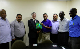 Secretary Anand Sanasie hands over a token of appreciation to Australia High Commissioner to Guyana John Pilbean.
