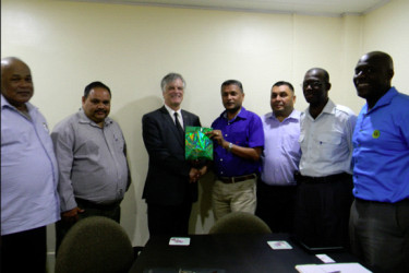 Secretary Anand Sanasie hands over a token of appreciation to Australia High Commissioner to Guyana John Pilbean. 
