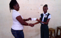 Winner of the first ever Linden youth business challenge Dacia Hamilton (right) collecting her winnings.