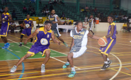Keon Cameron (centre) of Retrieve Raiders trying to maintain possession of the ball while being guarded by Travis Burnett (left) of Pacesetters in their semi-final showdown in the GABF Road To Mecca National Ckub Championship at the Cliff Anderson Sports Hall