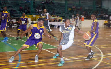 Keon Cameron (centre) of Retrieve Raiders trying to maintain possession of the ball while being guarded by Travis Burnett (left) of Pacesetters in their semi-final showdown in the GABF Road To Mecca National Ckub Championship at the Cliff Anderson Sports Hall 