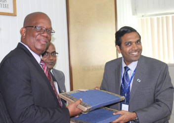 Minister of Finance Winston Jordan (left) and the Exim Bank Representative T.D. Sivakura exchanging documents after the signing.