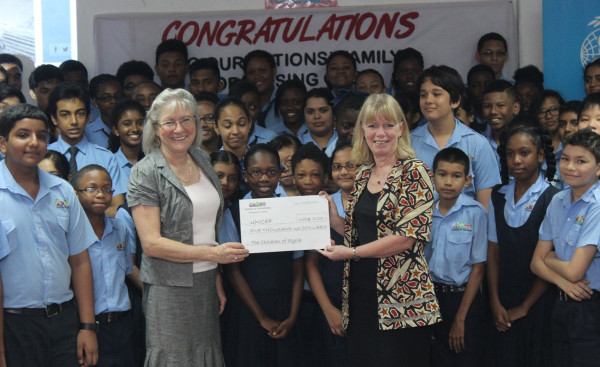 UNICEF Representative for Guyana and Suriname Marianne Flach (front, right) receives the donation from Principal of the school Pamela O’Toole while students look on 