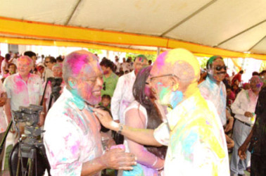 President David Granger (right) powdering former Prime Minister Sam Hinds (Ministry of the Presidency photo) 