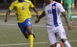Goal scorer Romario Harewood (left) tracks Curacao defender Germaine Augusten during their CFU Caribbean Cup match on Wednesday night. (Photo by Bernard Babb) 