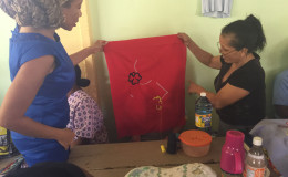 A prisoner holds up an embroidered piece she is working on 