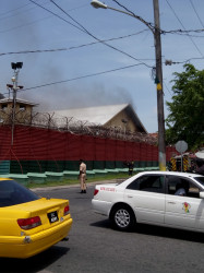 Smoke emanating from one of the buildings in the Camp Street prison today, where nine fires were set.