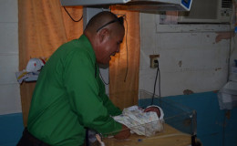 Minister of Public Health, Dr. George Norton holding a new- born baby who was delivered by staff of the Kwakwani Hospital minutes before the photo was taken. (GINA photo)