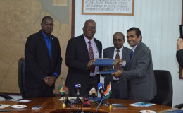 Minister of Finance Winston Jordan (second from left) and Resident Representative, Export/Import (EXIM) Bank of India, T.D Sivakumar with a signed copy of the credit agreement (GINA photo)