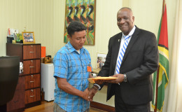 Toshao of the Toka Village in Lethem, North Rupununi (Region 9) Delano Davis (left) today received $200,000 from Minister of State Joseph Harmon. Harmon explained that the donation is to assist Toshao Davis to transport and accommodate a delegation from the village of Toka to Georgetown to visit various ministers and address concerns of the village. Minister Harmon undertook to make the contribution during a recent visit to Lethem. (Ministry of the Presidency photo)