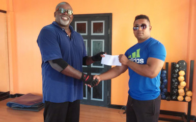 David Apparicio of Sabina Global Communities and Digital Technology’s Mustafa Hassan hands over corporate support to the GABBFF’s Videsh Sookram to help off set expenses of this year’s National Novices Championship. 