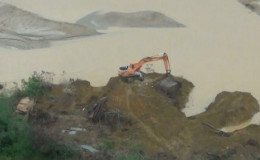 The excavator pushing the material into the river. (Ministry of Natural Resources photo)